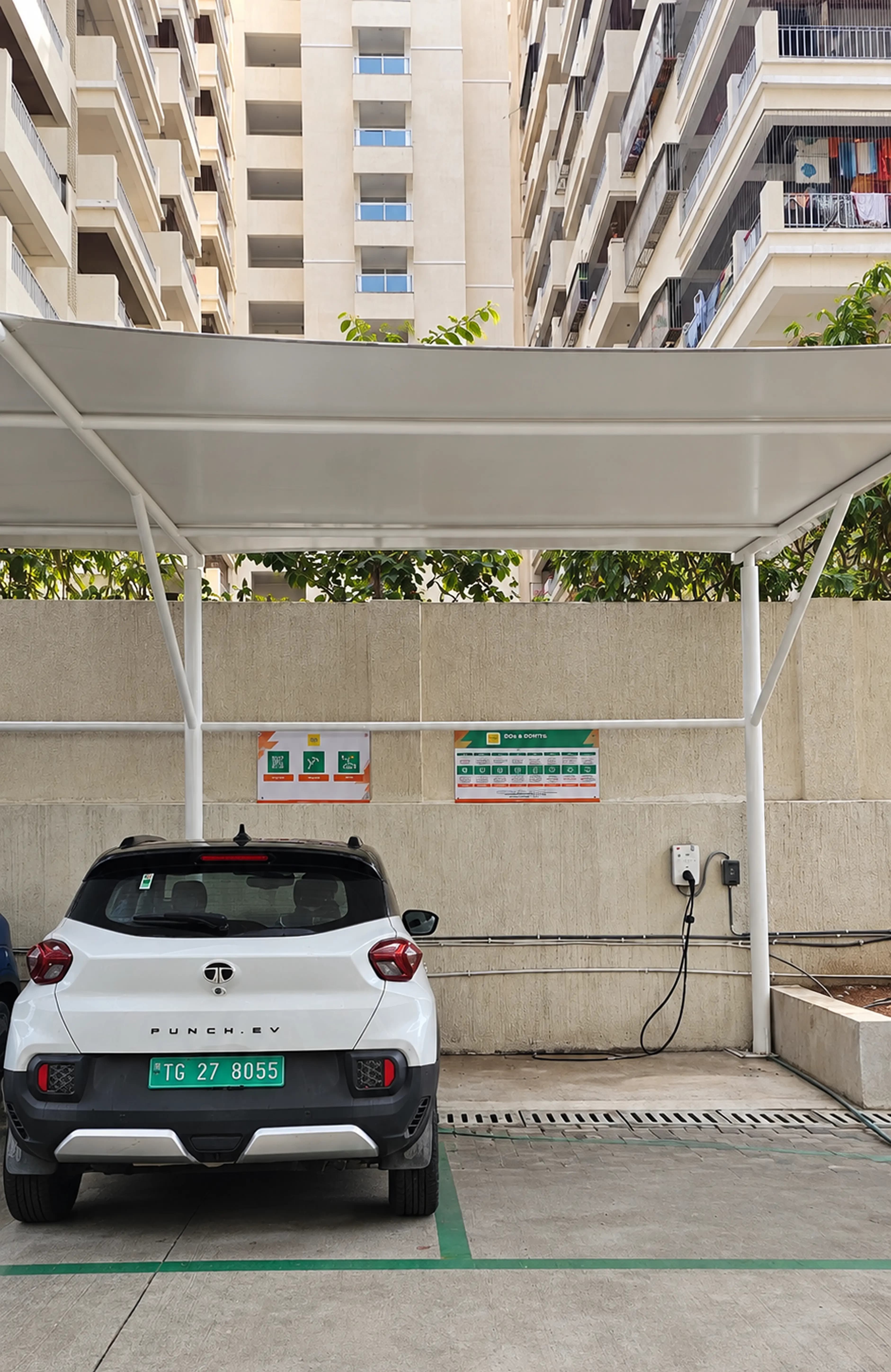 LionCharge chargers under a lit canopy at dusk, cars connected on a wet forecourt.